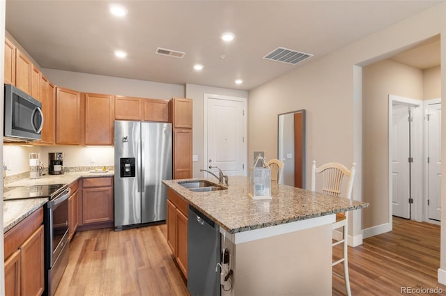 kitchen featuring appliances with stainless steel finishes, a sink, visible vents, and light wood-type flooring