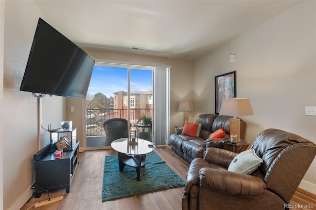 living room with baseboards, wood finished floors, and visible vents