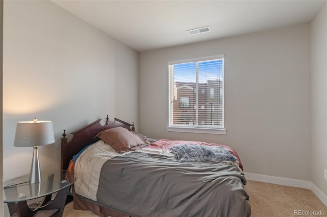 carpeted bedroom with visible vents and baseboards