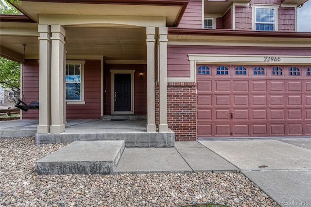 entrance to property with covered porch and a garage