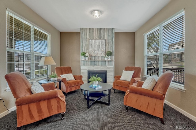 living area with carpet flooring, a fireplace, and baseboards
