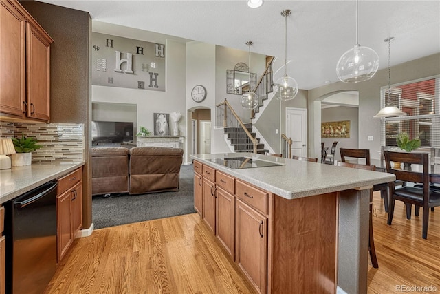 kitchen with light wood finished floors, brown cabinetry, and arched walkways