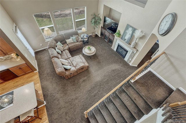 living room featuring carpet flooring, baseboards, and a glass covered fireplace