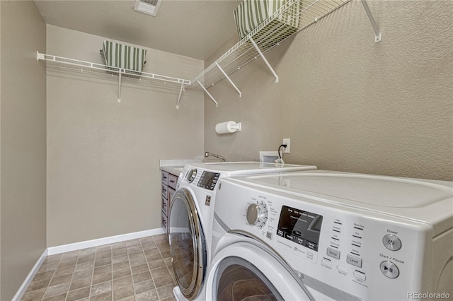 laundry area with washer and clothes dryer, visible vents, and baseboards