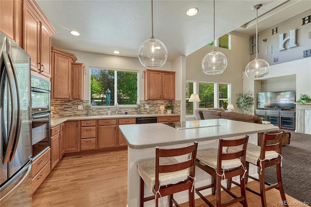 22965 Allendale Ave, Parker, CO 80138 - kitchen with black appliances, a textured ceiling, open floor plan, a breakfast bar, and plenty of natural light