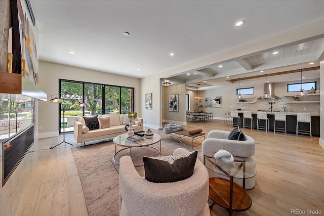 living room featuring light hardwood / wood-style flooring and beamed ceiling