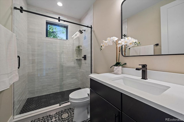 bathroom with a shower with shower door, toilet, and vanity