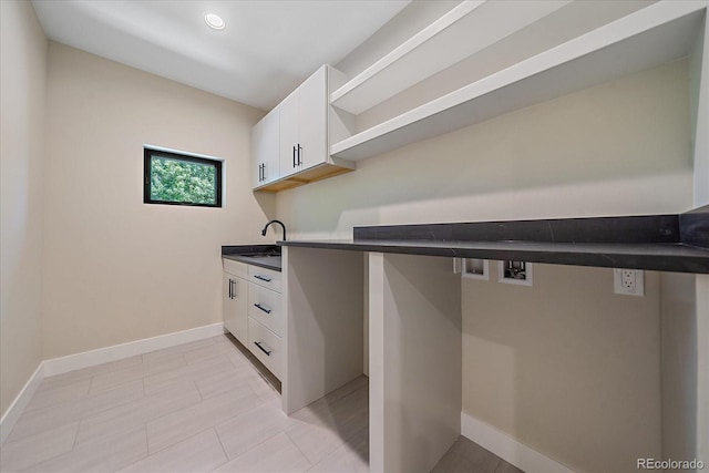 laundry room featuring sink, hookup for a washing machine, and cabinets