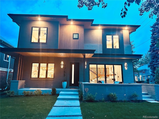 contemporary house featuring covered porch and a front lawn