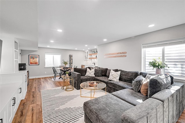 living room featuring indoor bar and light hardwood / wood-style flooring