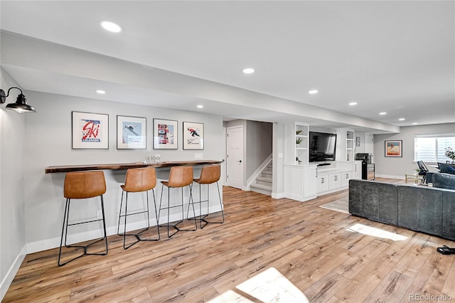 interior space with white cabinetry, built in features, and light hardwood / wood-style flooring