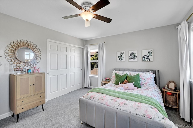 bedroom with ceiling fan, carpet floors, and a closet