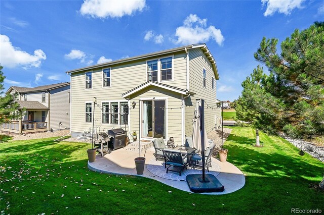 rear view of house with a yard and a patio