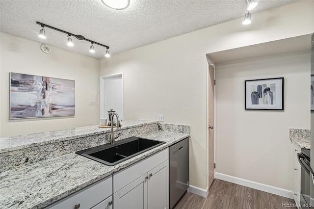 kitchen with dishwasher, a textured ceiling, a sink, and dark wood-style floors