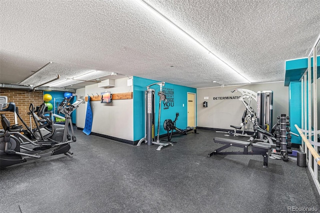 exercise room featuring baseboards and a textured ceiling