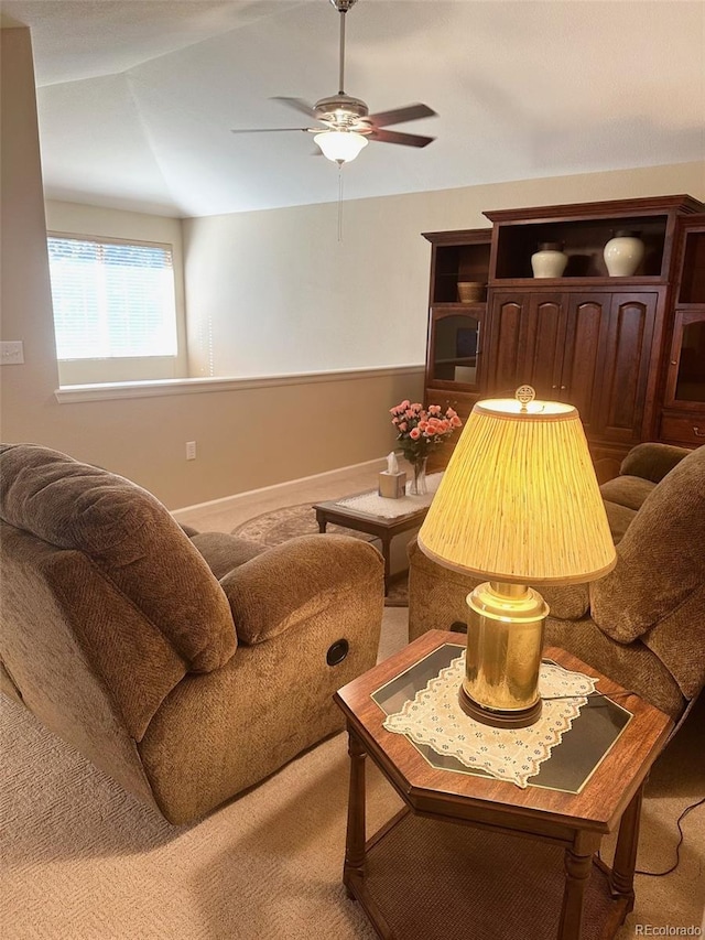 living area with carpet flooring, vaulted ceiling, and ceiling fan