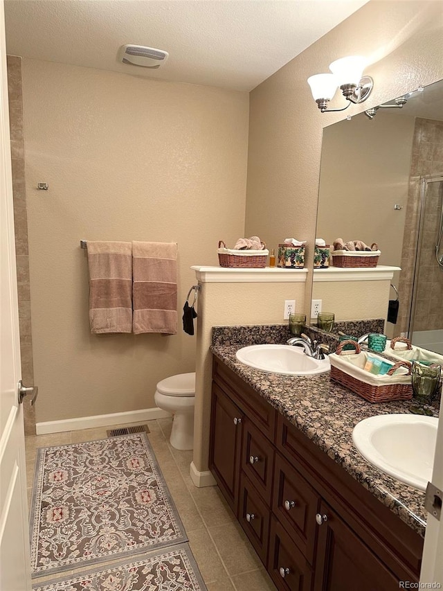 bathroom with a textured ceiling, an enclosed shower, toilet, tile patterned floors, and vanity