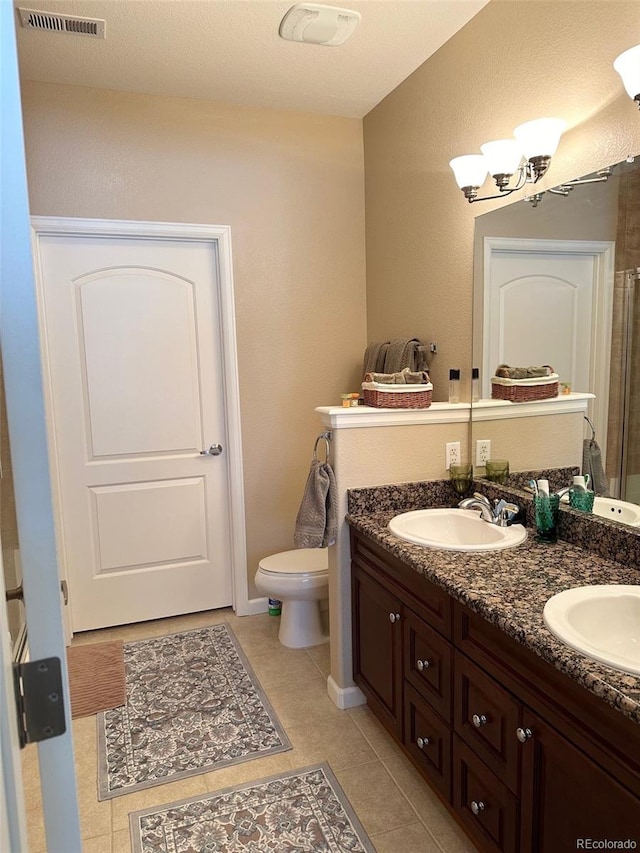 bathroom featuring vanity, a textured ceiling, toilet, and tile patterned flooring