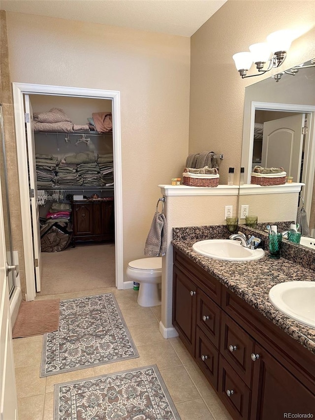 bathroom featuring vanity, an enclosed shower, toilet, and tile patterned floors