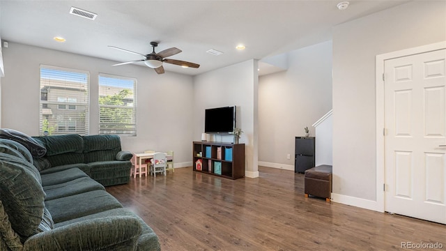 living room featuring dark hardwood / wood-style flooring and ceiling fan