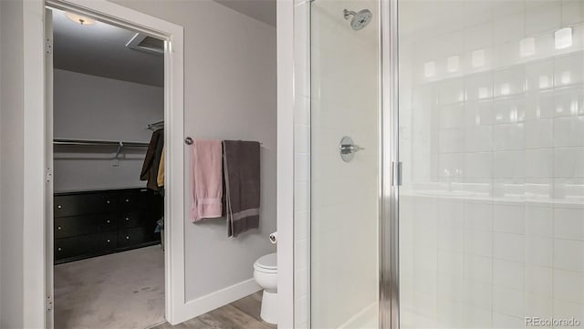 bathroom with hardwood / wood-style flooring, toilet, and an enclosed shower