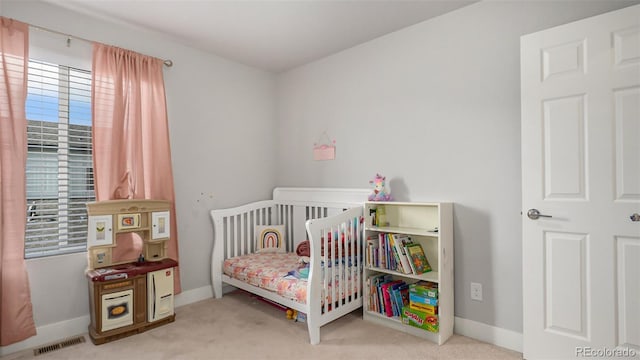 carpeted bedroom with a nursery area