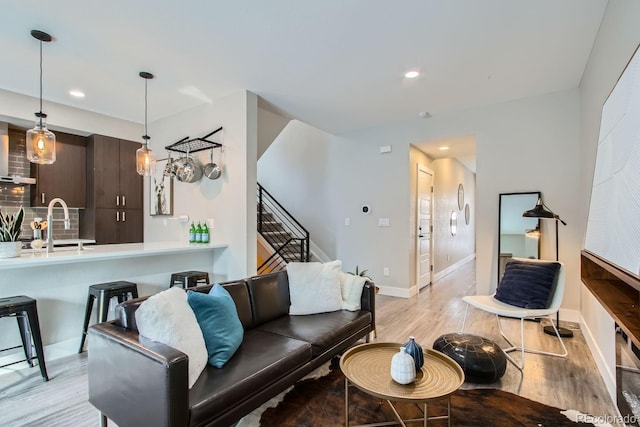 living room with sink and light hardwood / wood-style flooring