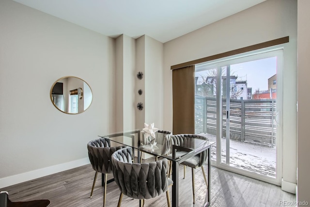 dining space featuring wood finished floors and baseboards