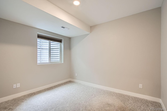 carpeted empty room with visible vents and baseboards