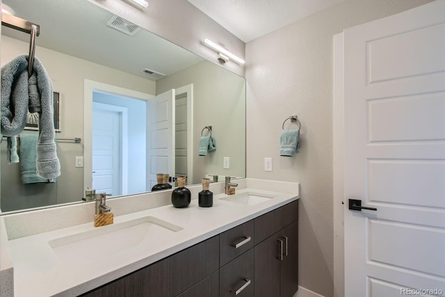 full bath with double vanity, visible vents, and a sink