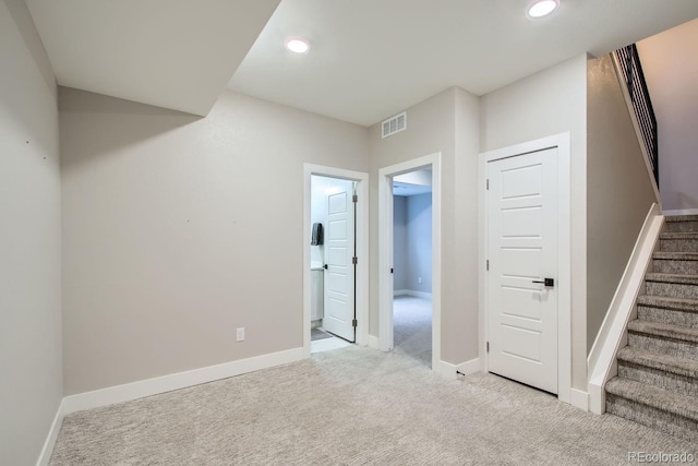 interior space with stairs, visible vents, baseboards, and carpet flooring