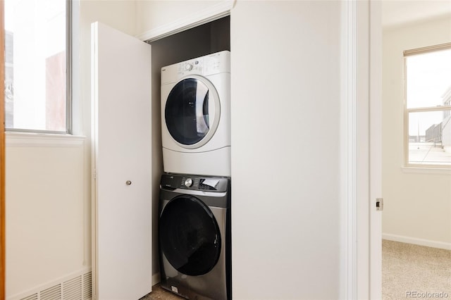 2680 Blake St Unit 12, Denver, CO 80205 - laundry area featuring stacked washer / dryer, baseboards, and carpet flooring