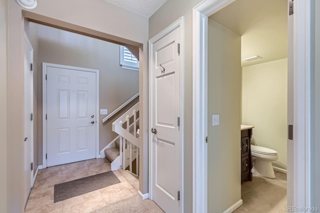 1470 S Quebec Way Unit 46, Denver, CO 80231 - entryway with light tile patterned flooring, stairway, and baseboards