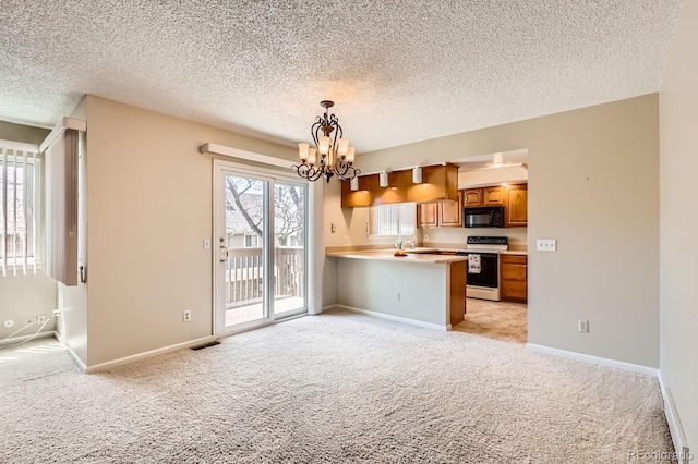 1470 S Quebec Way Unit 46, Denver, CO 80231 - kitchen featuring black microwave, range with electric cooktop, light colored carpet, a peninsula, and a chandelier