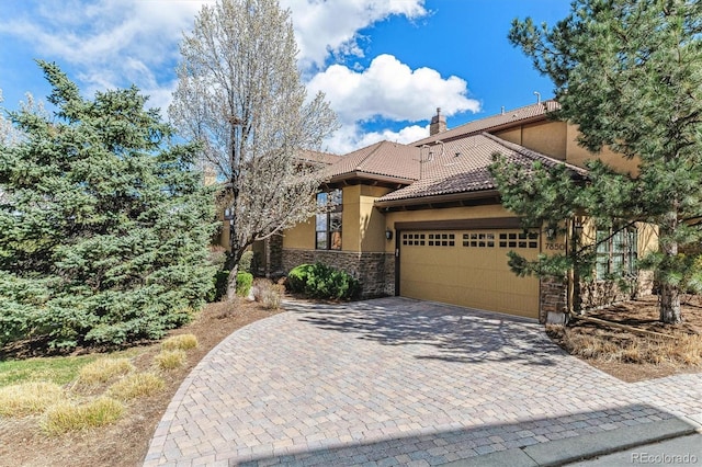 7850 Vallagio Ln, Englewood, CO 80112 - mediterranean / spanish-style house with a garage, stucco siding, driveway, stone siding, and a tiled roof