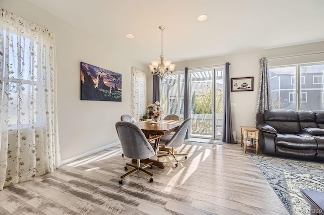 dining space with wood-type flooring and a chandelier