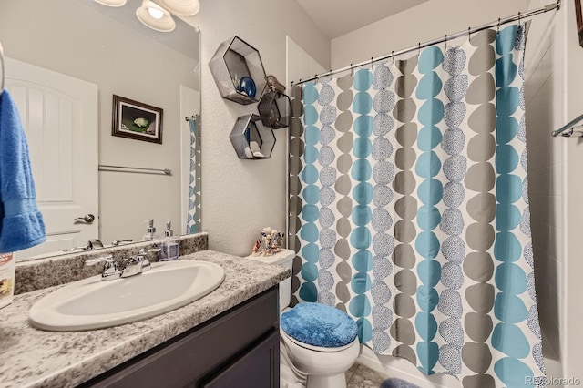 bathroom featuring toilet, vanity, and walk in shower