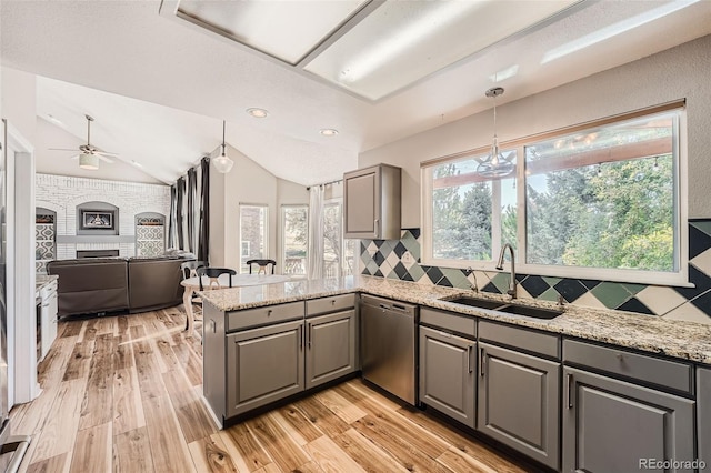 kitchen featuring light hardwood / wood-style flooring, kitchen peninsula, sink, gray cabinets, and stainless steel dishwasher