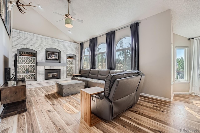 living room featuring light hardwood / wood-style flooring, a textured ceiling, and plenty of natural light