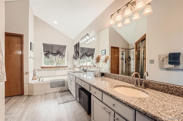 bathroom with vanity, hardwood / wood-style floors, high vaulted ceiling, and separate shower and tub