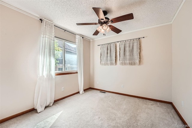 carpeted empty room featuring ceiling fan, a textured ceiling, and ornamental molding