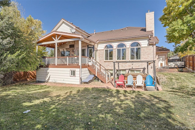 back of property featuring a yard and a wooden deck