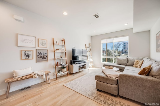 living area featuring light wood-style floors, baseboards, visible vents, and recessed lighting