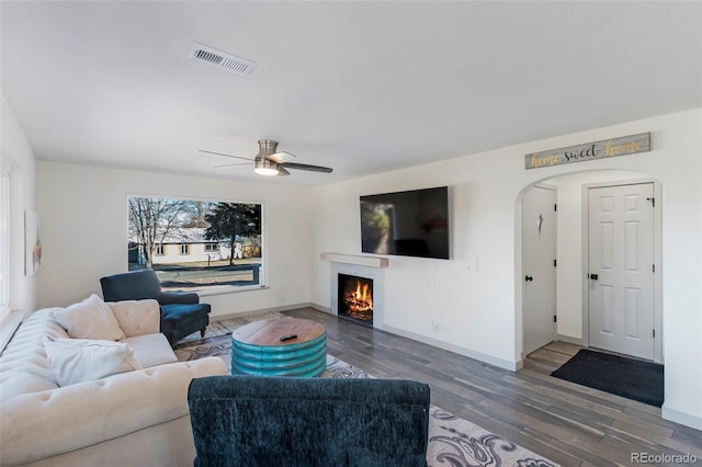 living room with ceiling fan and dark hardwood / wood-style flooring