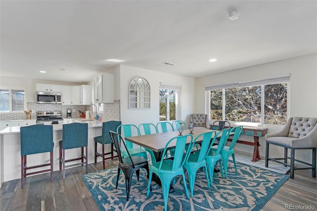 dining room featuring dark hardwood / wood-style flooring, sink, and a wealth of natural light