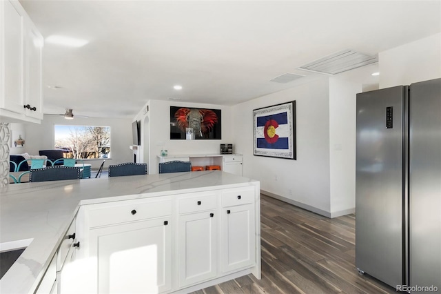 kitchen featuring white cabinets, dark hardwood / wood-style floors, and stainless steel fridge