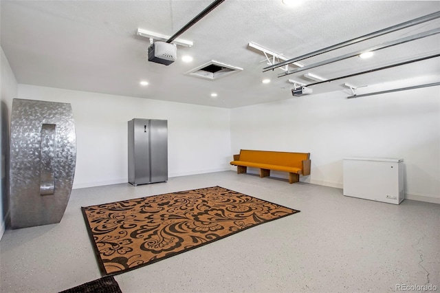 garage with a garage door opener and fridge