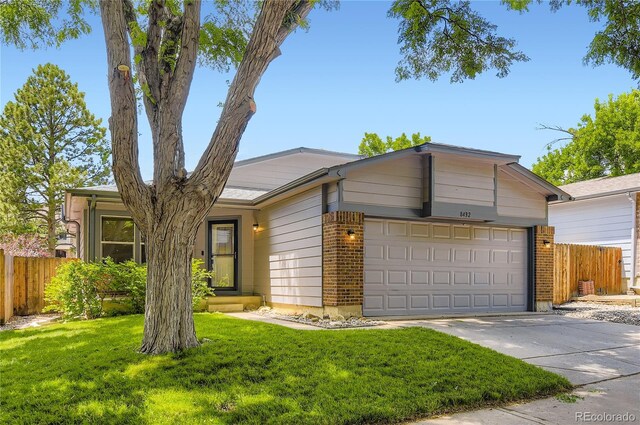 8432 S Upham Way, Littleton, CO 80128 - view of front of property with a garage, concrete driveway, and brick siding