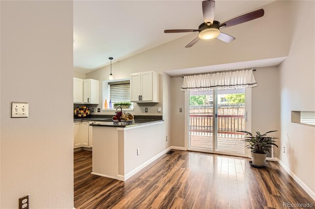8432 S Upham Way, Littleton, CO 80128 - kitchen with dark wood-style floors, a ceiling fan, white cabinets, dark countertops, and a peninsula