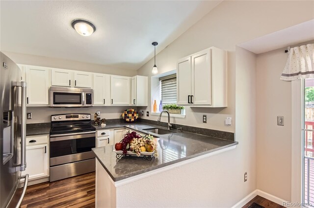 8432 S Upham Way, Littleton, CO 80128 - kitchen with appliances with stainless steel finishes, lofted ceiling, a peninsula, white cabinets, and dark wood-type flooring